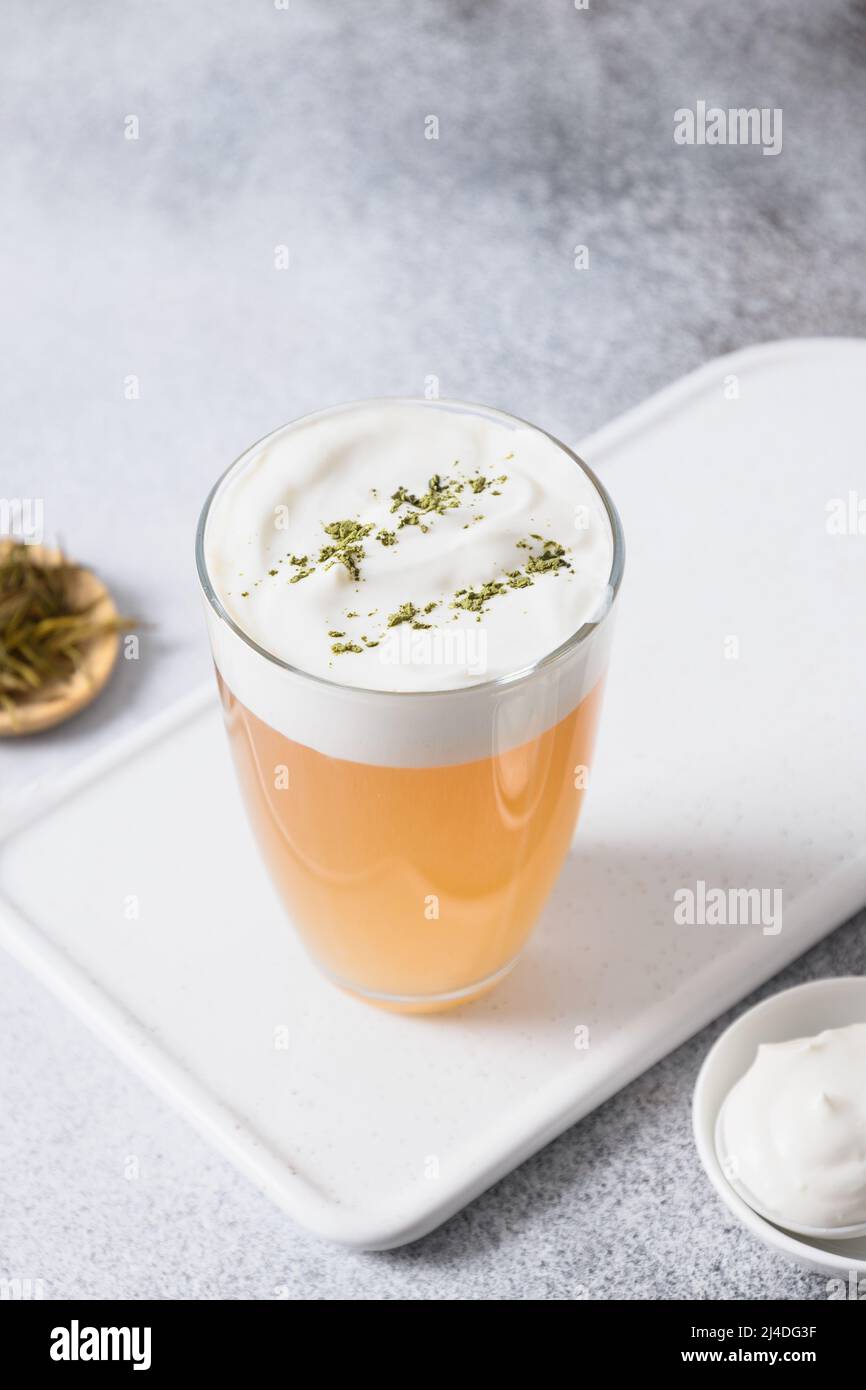 Tè Cinese al formaggio con strato di schiuma cremosa su sfondo bianco. Bevanda asiatica alla moda. Thailandese tè al latte. Formato verticale. Primo piano. Foto Stock
