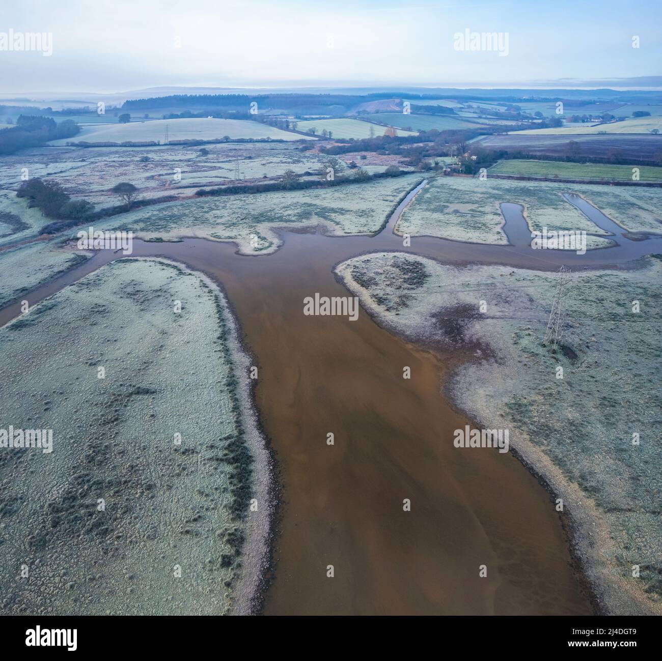 Misty Sunrise sopra le paludi e i prati ghiacciati, RSPB Exminster e Powderham Marshe da un drone, Exeter, Devon, Inghilterra Foto Stock