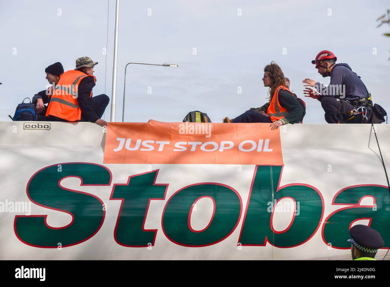 Londra, Regno Unito, 14th aprile 2022. Poliziotti con manifestanti in cima alla petroliera. Gli attivisti Just Stop Oil si sono incollati alla sommità di una petroliera e hanno bloccato il traffico sulla rotatoria di Chiswick a Londra occidentale per protestare contro i combustibili fossili. Il gruppo intende interrompere il flusso di petrolio nel capitale. Credit: Vuk Valcic/Alamy Live News Foto Stock