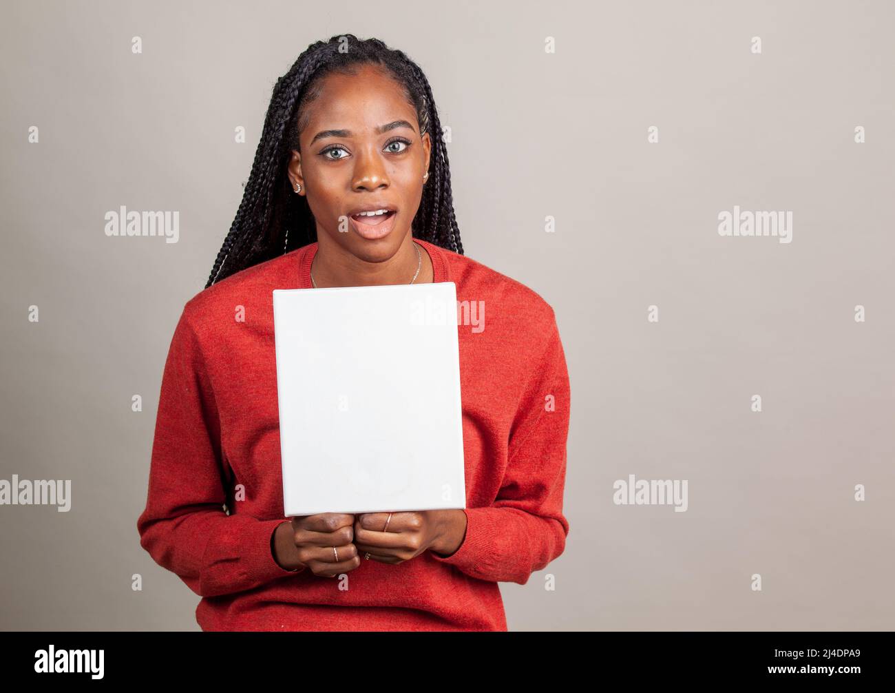 African American donna con occhi blu tenendo un cartello con una stanza per la copia. L'immagine pubblicitaria con camera per la copia Foto Stock