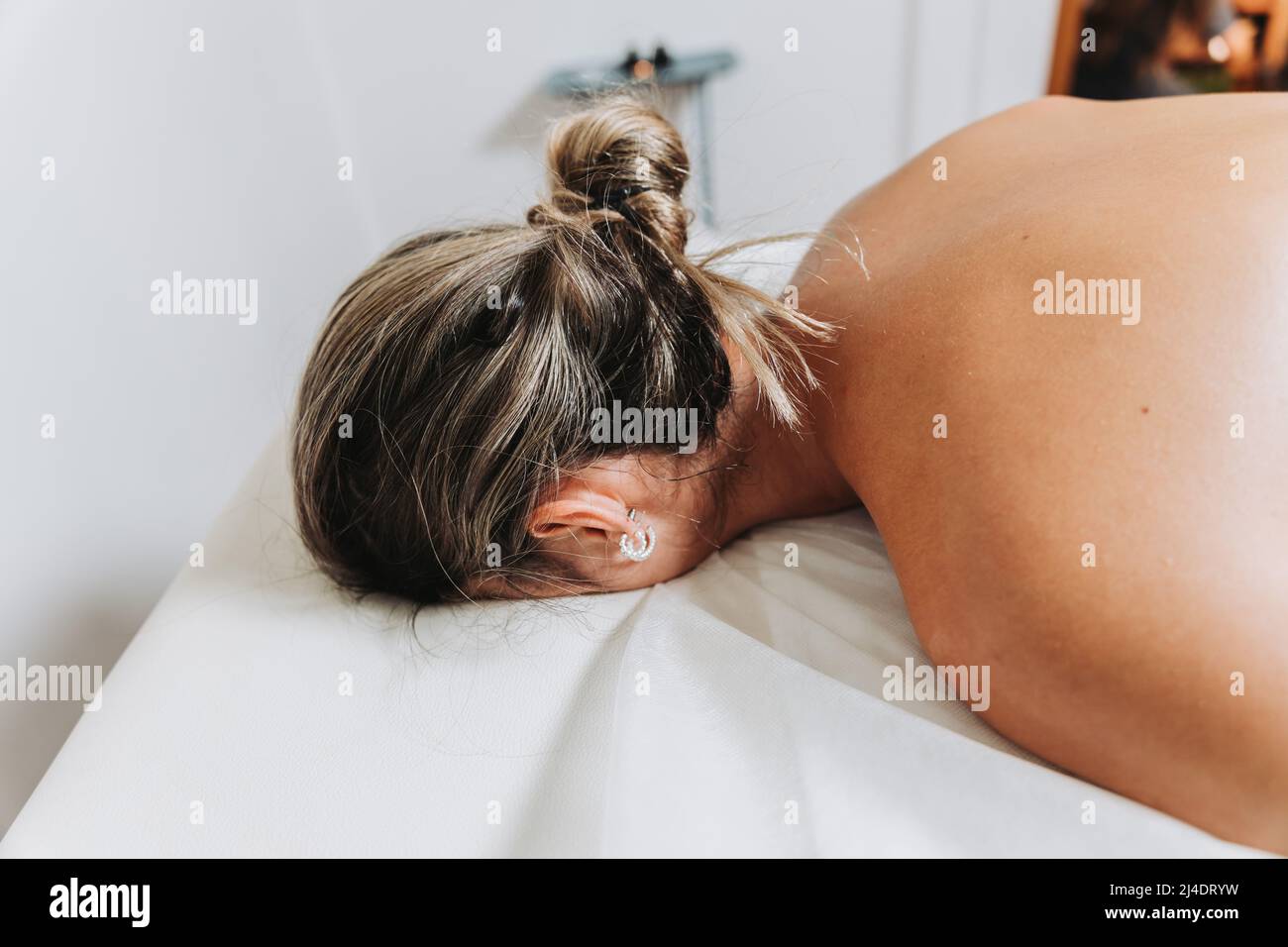 Paziente femminile irriconoscibile faccia in giù e rilassato, pronto per ottenere un massaggio. Relax e stress Foto Stock