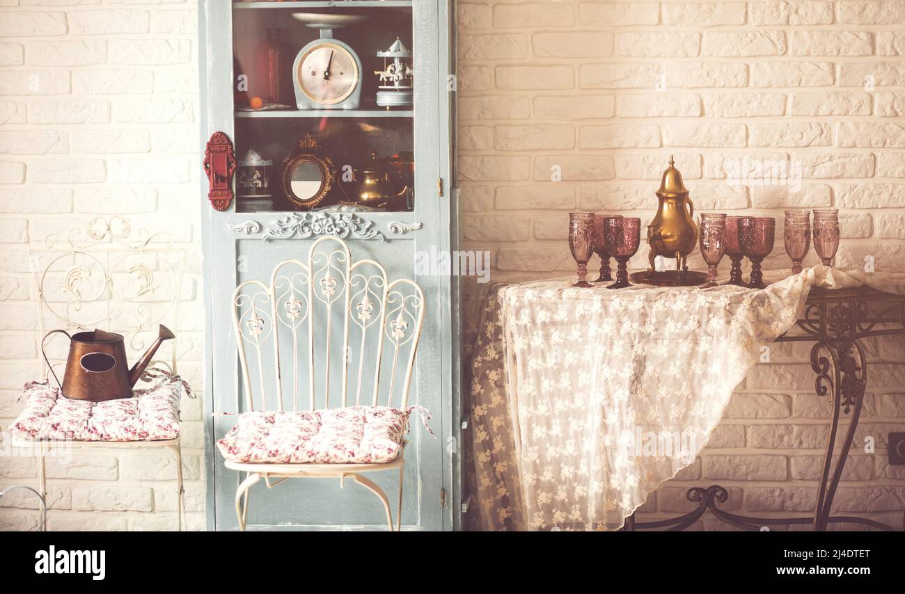 sedia e tavolo vintage con wineglass. Armadio in legno. Foto Stock