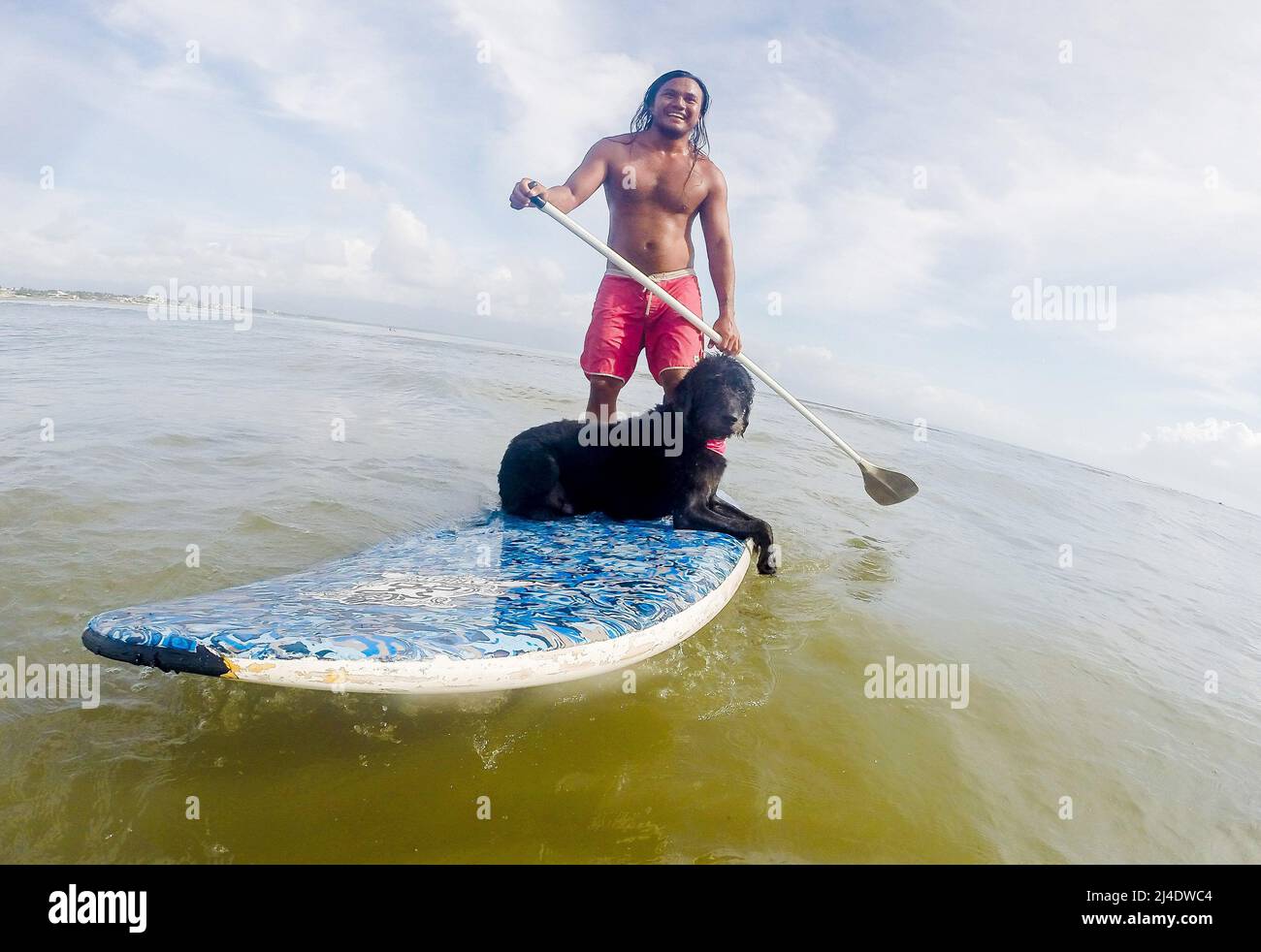 Provincia di Aurora, Filippine. 14th Apr 2022. Il surfista Mario Cardama Jr. E il cane Gordy surf in una spiaggia nella provincia di Aurora, nelle Filippine, 14 aprile 2022. Fondato nel 2016, il Dog Collective è costituito da appassionati di surf che sono anche amanti del cane. Trascorrono il loro tempo libero insegnando ai loro animali domestici adottisi a fare un giro in tavola da surf nel comune di Baler nella provincia di Aurora, che è localmente conosciuta come 'il luogo di nascita del surf delle Filippine.' Credit: Rouelle Umali/Xinhua/Alamy Live News Foto Stock