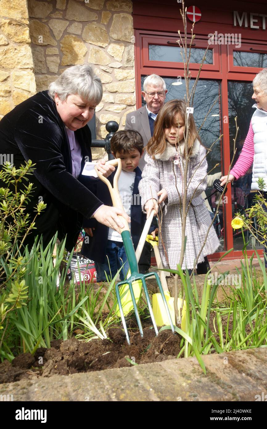 Il ministro della Chiesa e due bambini che piantano un albero per celebrare il Queens Platinum Jubillee 2022 Stratford upon Avon UK Foto Stock