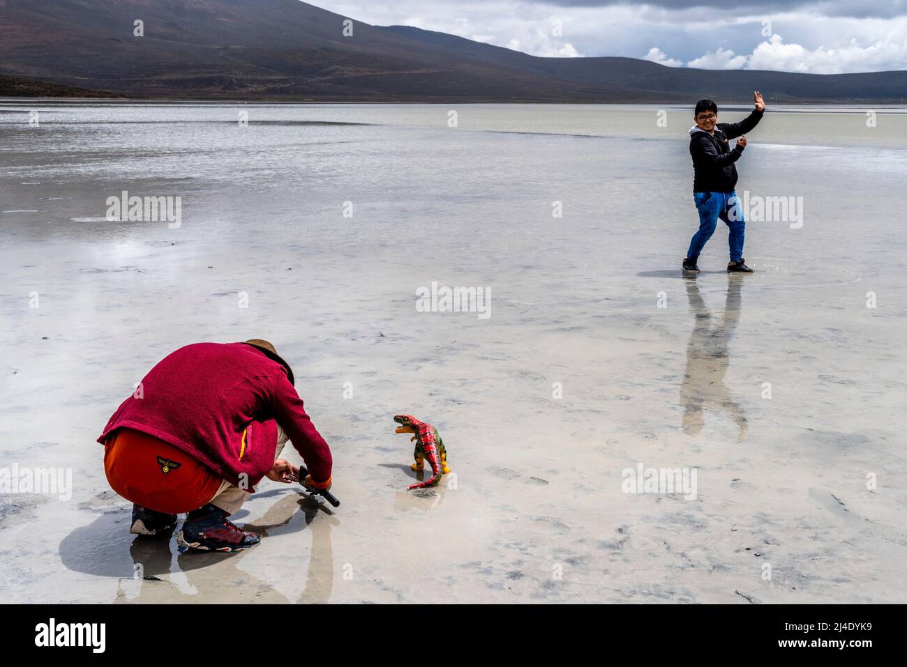 I visitatori posano per le foto con un dinosauro giocattolo al Salar de Moche (Lago Salinas) Salt Lake vicino alla città di Arequipa, regione di Arequipa, Perù. Foto Stock