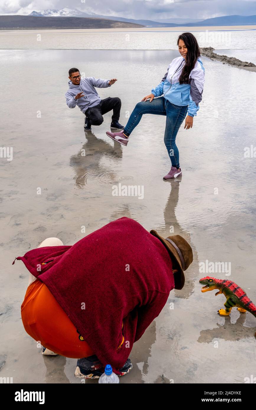 I visitatori posano per le foto con un dinosauro giocattolo al Salar de Moche (Lago Salinas) Salt Lake vicino alla città di Arequipa, regione di Arequipa, Perù. Foto Stock