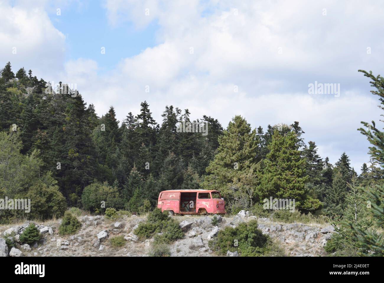 Abbandonato furgone rosso nella foresta, situato a Parnonas montagna, Kynouria sud. Escursioni e natura greca. Arcadia, Peloponneso, Grecia Foto Stock