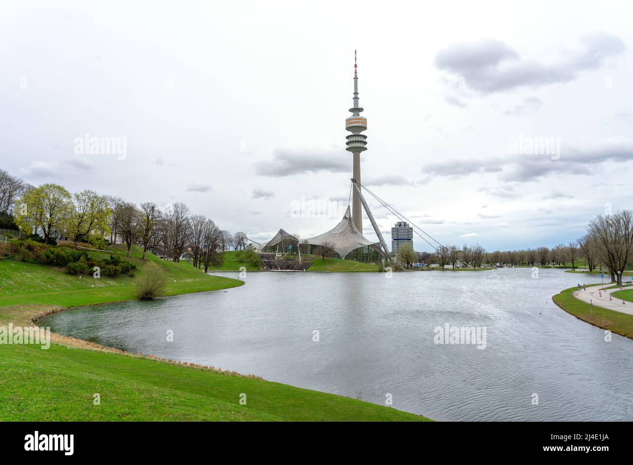 Parco Olympia a Monaco di Baviera Germania con un laghetto e la torre alta Foto Stock