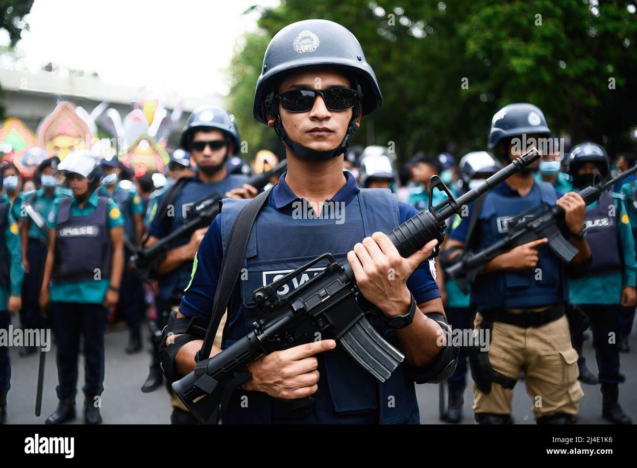 I membri della forza speciale di sicurezza 'SWAT (armi speciali e tattiche)' sono schierati durante la celebrazione del primo giorno del nuovo anno bengalese. Il popolo del Bangladesh partecipa a una sfilata colorata per celebrare il primo giorno del capodanno bengalese o Pohela Boishakh il 14 aprile. Migliaia di persone del Bangladesh lo celebrano con diversi rally colorati, programmi culturali con danza tradizionale e musica, questo anno bengalese è stato introdotto durante il regime dell'imperatore Akbar per facilitare la raccolta delle entrate nel 16th secolo. Foto Stock