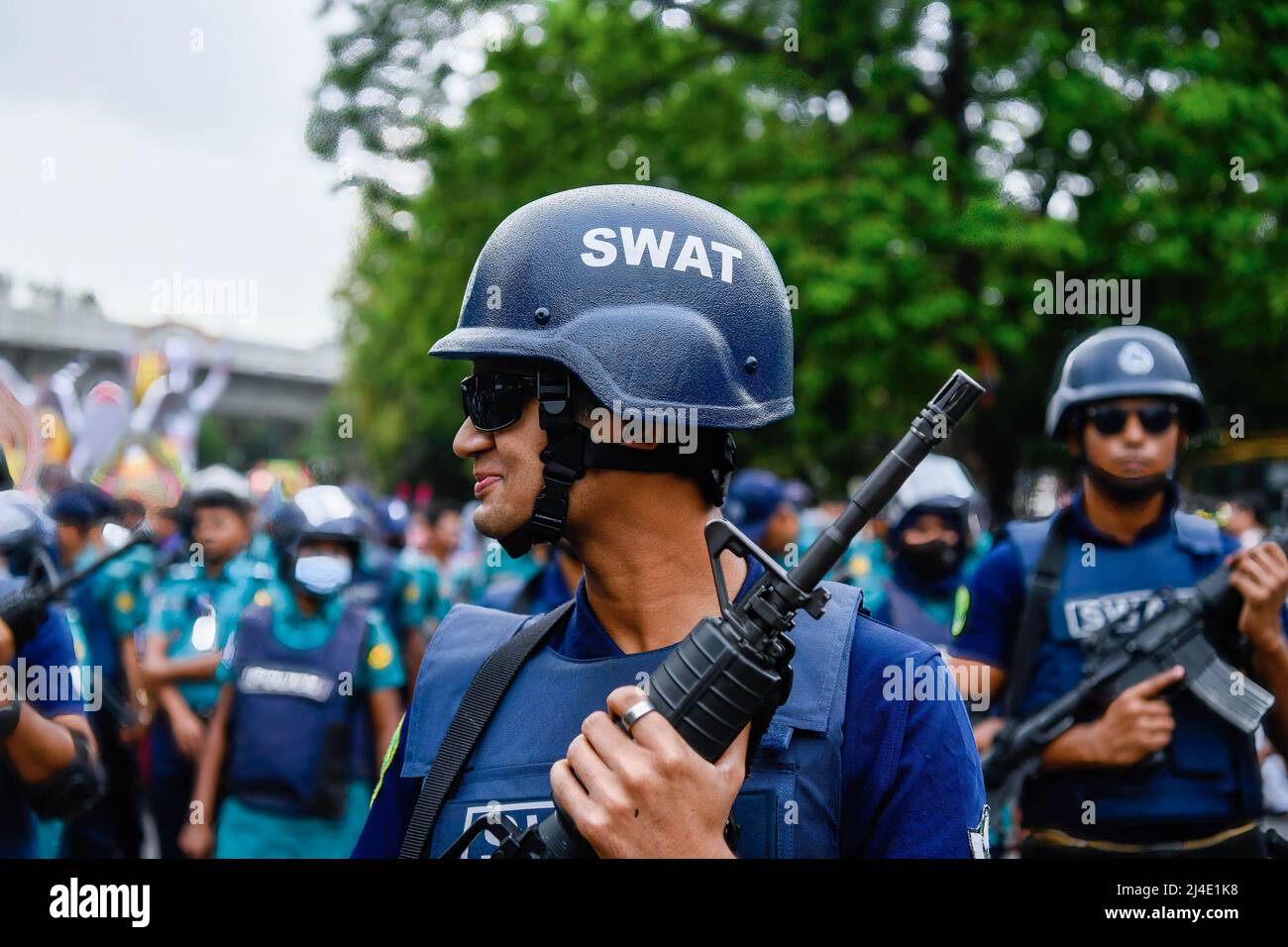 I membri della forza speciale di sicurezza 'SWAT (armi speciali e tattiche)' sono schierati durante la celebrazione del primo giorno del nuovo anno bengalese. Il popolo del Bangladesh partecipa a una sfilata colorata per celebrare il primo giorno del capodanno bengalese o Pohela Boishakh il 14 aprile. Migliaia di persone del Bangladesh lo celebrano con diversi rally colorati, programmi culturali con danza tradizionale e musica, questo anno bengalese è stato introdotto durante il regime dell'imperatore Akbar per facilitare la raccolta delle entrate nel 16th secolo. Foto Stock