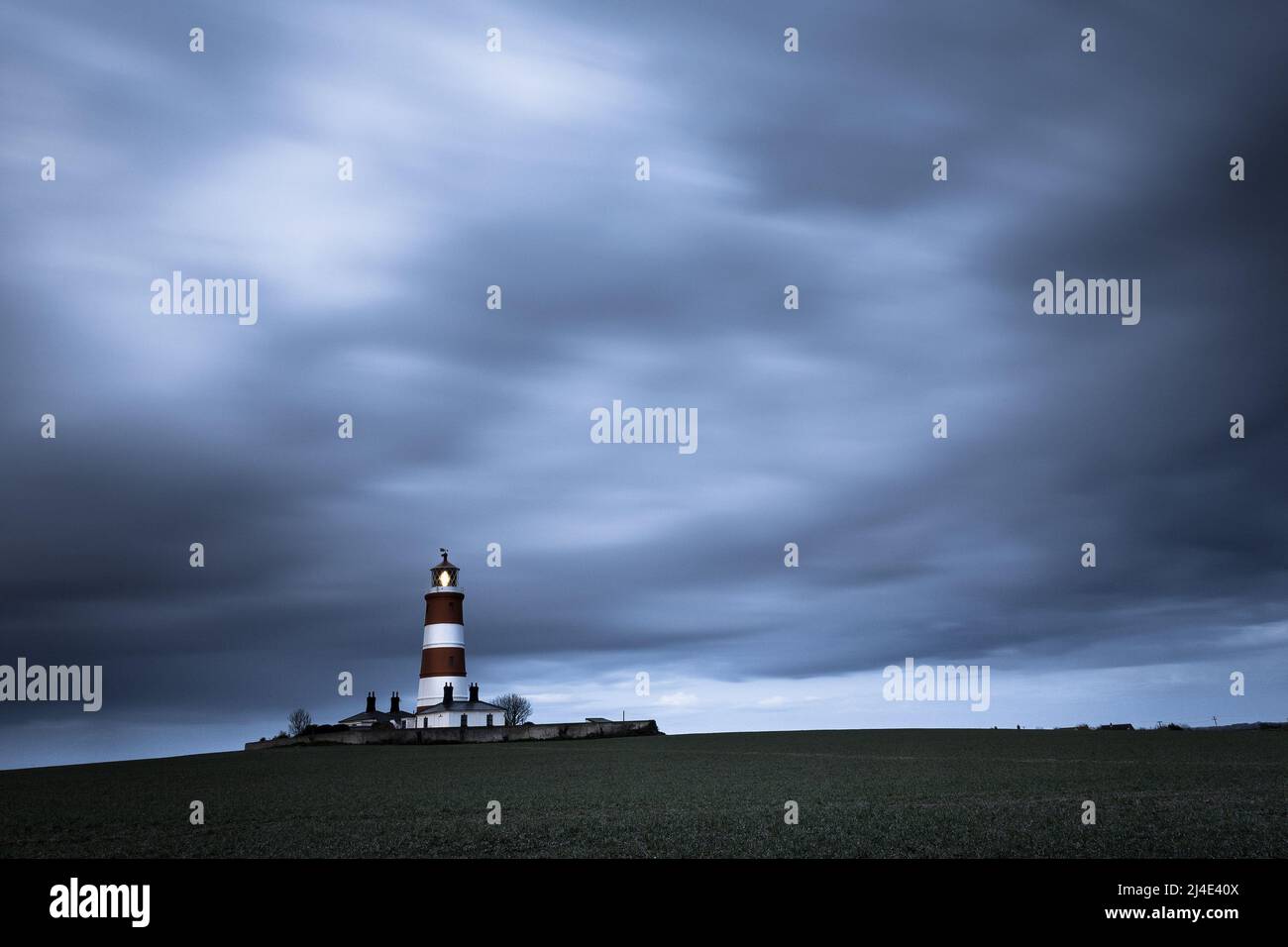 Cielo tempestoso dietro il faro di Happisburgh sulla costa di Norfolk, Regno Unito Foto Stock