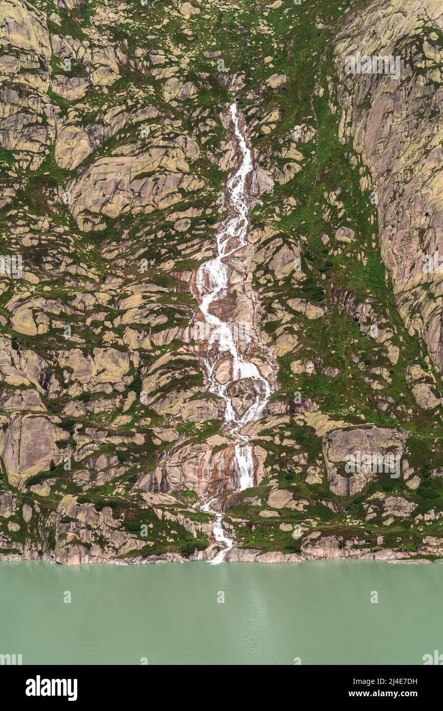 Un torrente glaciale che confluisce nel Grimselsee in Svizzera Foto Stock