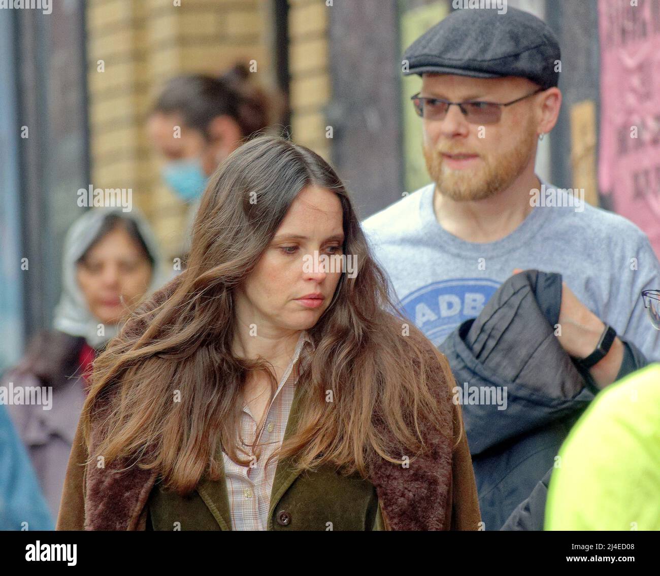 Glasgow, Scozia, Regno Unito 14th aprile, 2022 Hollywood arriva in città ancora una volta per il modo di avere visto la signorina jones come Felicity Jones filma in città ha visto una serie di occhi molto scintillante come ha guardato ogni pollice una stella del film tra gli anni settanta drab Londra set che è Glasgow.. Si vede lasciare il famoso pub di glasgow il griffin e andare a e telefonare da una scatola telefonica rossa. Credit Gerard Ferry/Alamy Live News Foto Stock