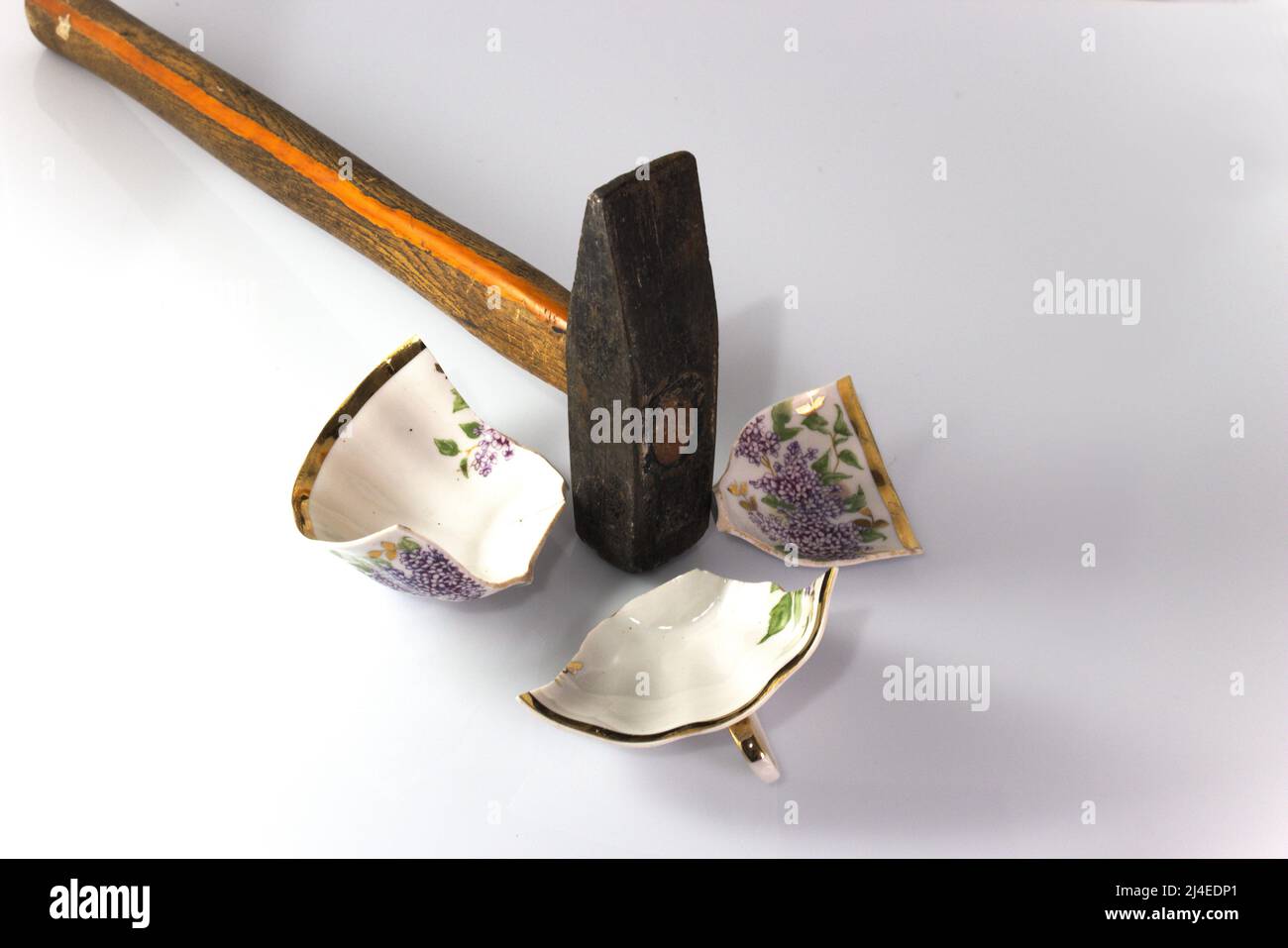 Tazza rotta da un martello. Su sfondo di legno. Concetto. Foto Stock