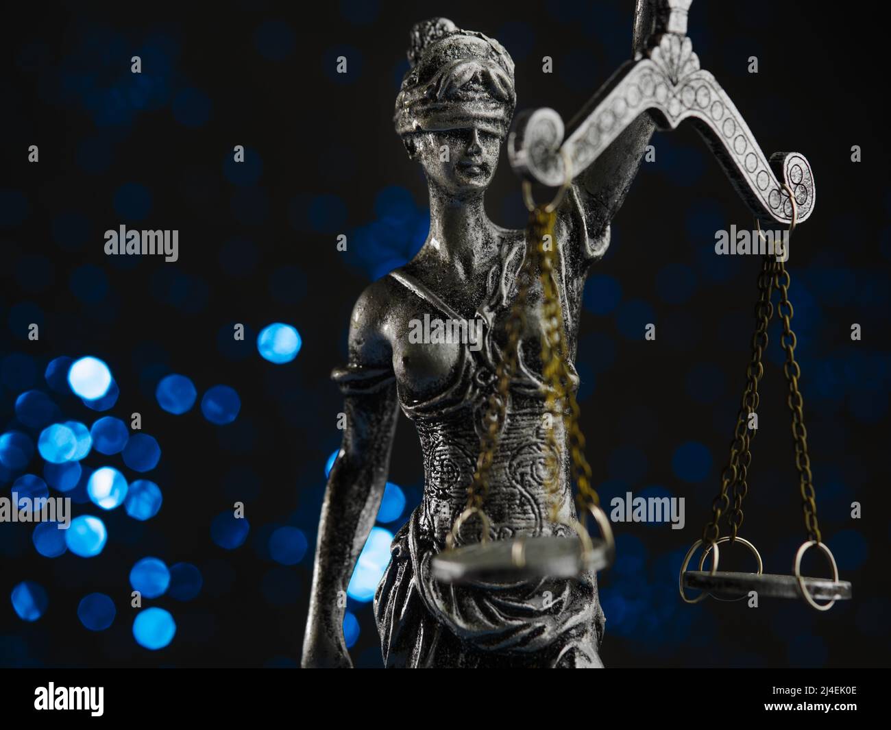 Figurina di bronzo di Themis - la dea della giustizia su sfondo blu con luci scintillanti. Simbolo di diritto, giustizia, indipendenza. Lo Stato di diritto. Foto Stock