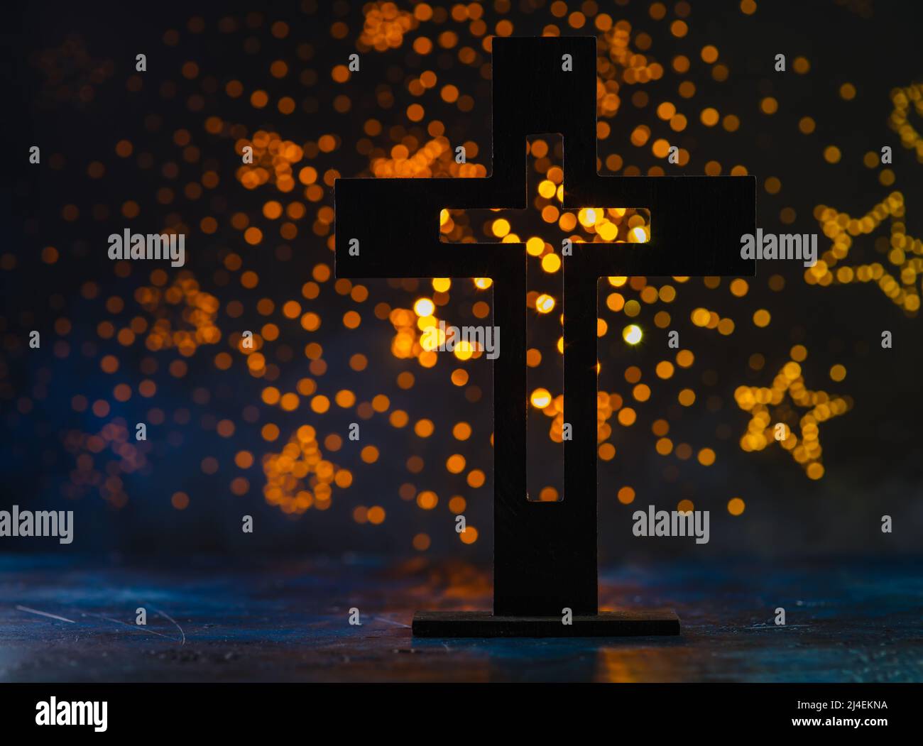Croce cattolica su sfondo blu con stelle gialle scintillanti. Simbolo di fede e spiritualità, amore e perdono. Religione, cattolicesimo, crucif Foto Stock