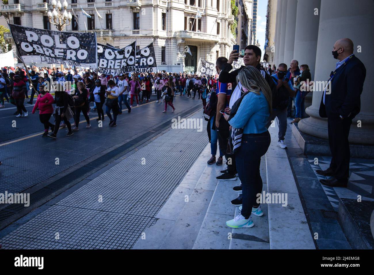 Buenos Aires, Argentina. 13th Apr 2022. Un gruppo di turisti alla Cattedrale di Buenos Aires scatta foto delle colonne di manifestanti che si dirigono verso la Piazza maggio. Le organizzazioni di sinistra che compongono l'unità Piquetera hanno di nuovo effettuato una mobilitazione verso la Piazza di Maggio a causa della mancanza di risposte alle loro richieste sociali da parte del Ministro dello sviluppo sociale, John Zabaleta. (Foto di Nacho Boullosa/SOPA Images/Sipa USA) Credit: Sipa USA/Alamy Live News Foto Stock