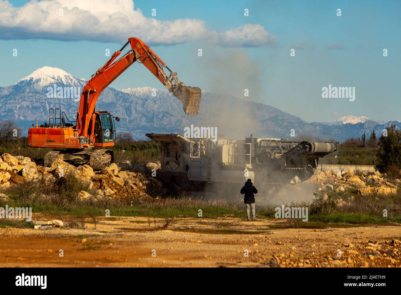 Frantumatore pieno di pietra con frantumatore di pietra e benna Foto Stock