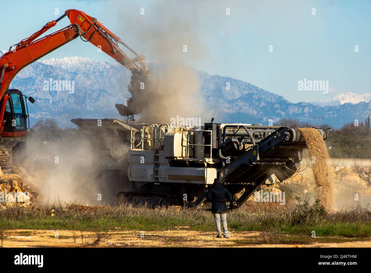 Frantumatore pieno di pietra con frantumatore di pietra e benna Foto Stock