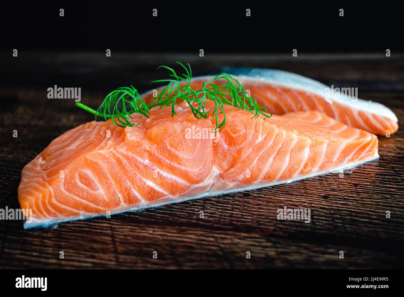Filetti di salmone crudo guarniti con aneto fresco: Vista a chiosco di filetti di pesce grasso non cotti Foto Stock