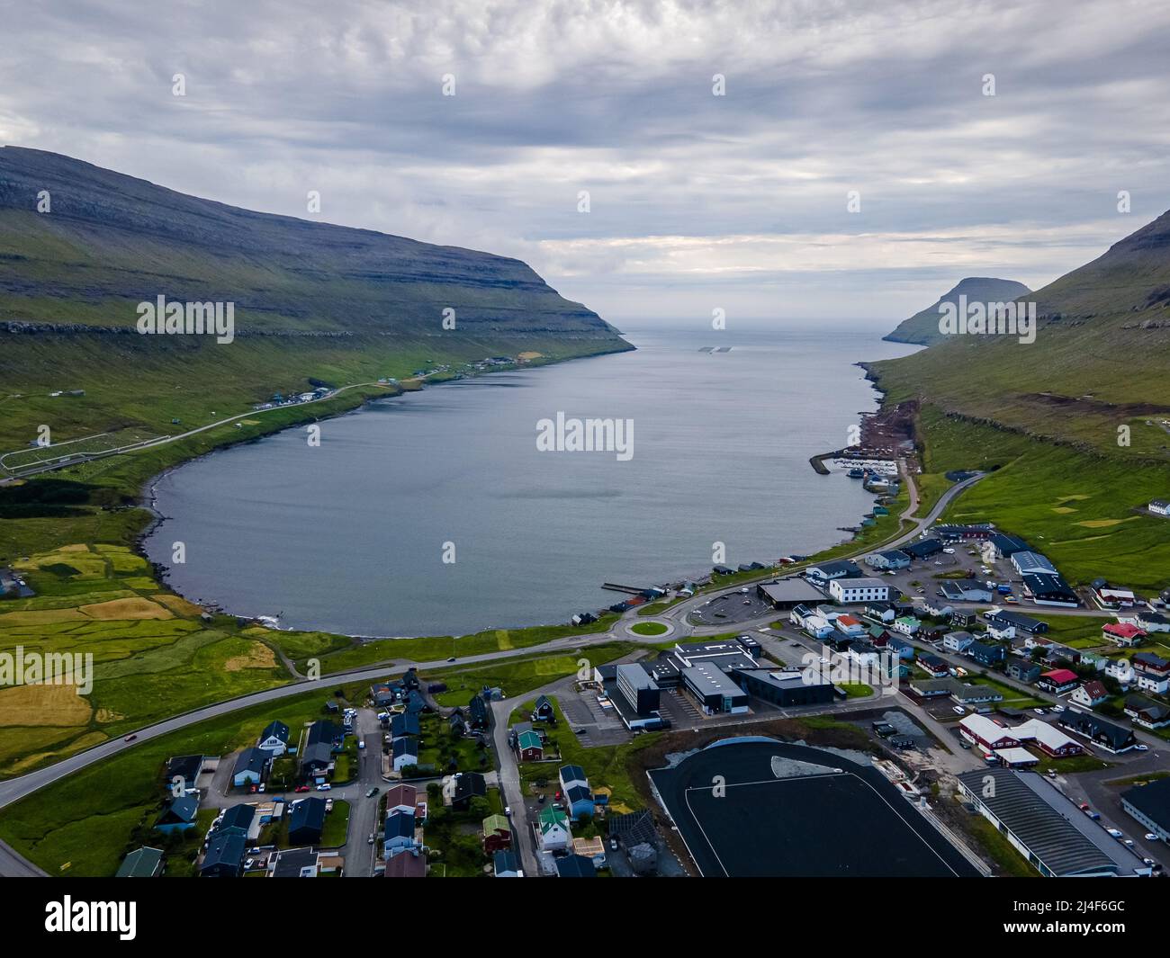 Splendida vista aerea della città di Kraksvik nelle Isole Fareo con le sue case colorate e il canale incredibile e vista sul maestoso Kunoy Park Foto Stock