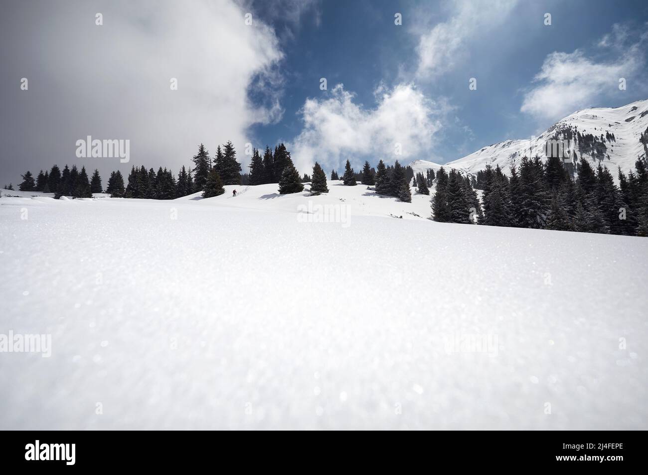 Uomo con zaino che cammina sulla collina della neve con le impronte ad Almaty, Kazakhstan Foto Stock