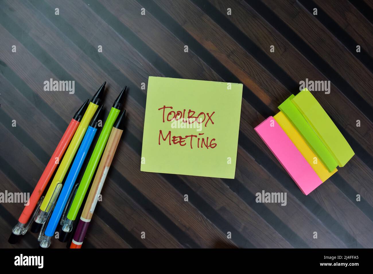 Toolbox Meeting scrivere su note appiccicose isolate su tavola di legno. Foto Stock