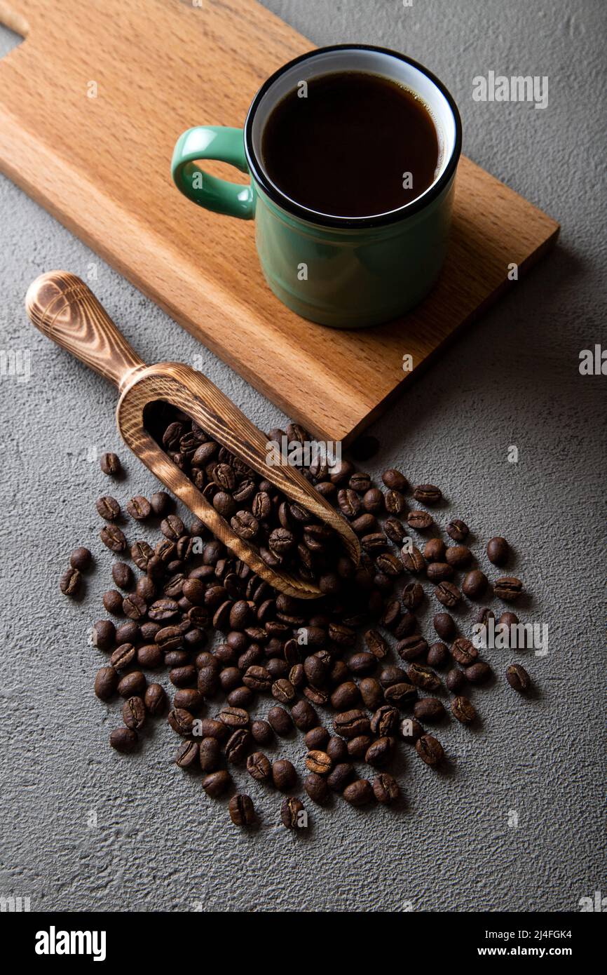 Tazza di caffè verde con chicchi di caffè su sfondo di cemento Foto Stock