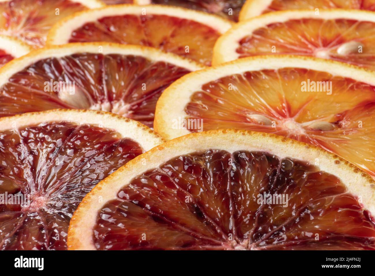 Sfondo astratto con frutta di fette d'arancia. Motivo di citruse rosso arancio. Primo piano estremo Foto Stock