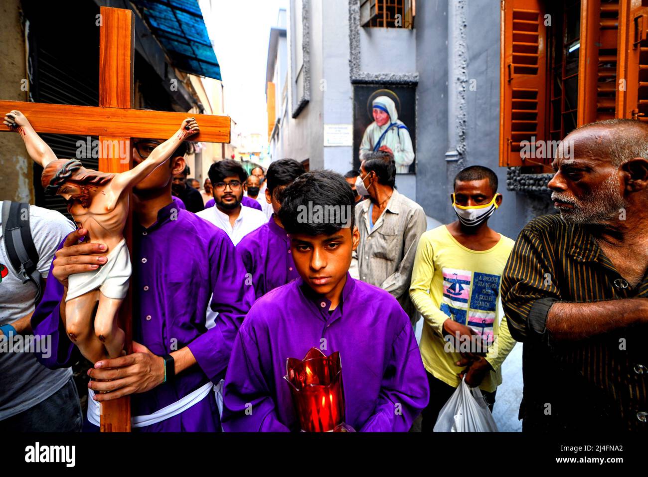 Giovani e devoti cristiani hanno visto portare una croce fuori dai Missionari della Carità mentre prendono parte alla processione religiosa durante il Venerdì Santo . Il Venerdì Santo è una festa cristiana che commemora la crocifissione di Gesù Cristo e la sua morte al Calvario. Si osserva durante la settimana Santa come parte del Triduo Pasquale il venerdì che precede la domenica di Pasqua, e può coincidere con l'osservanza ebraica della Pasqua. Foto Stock