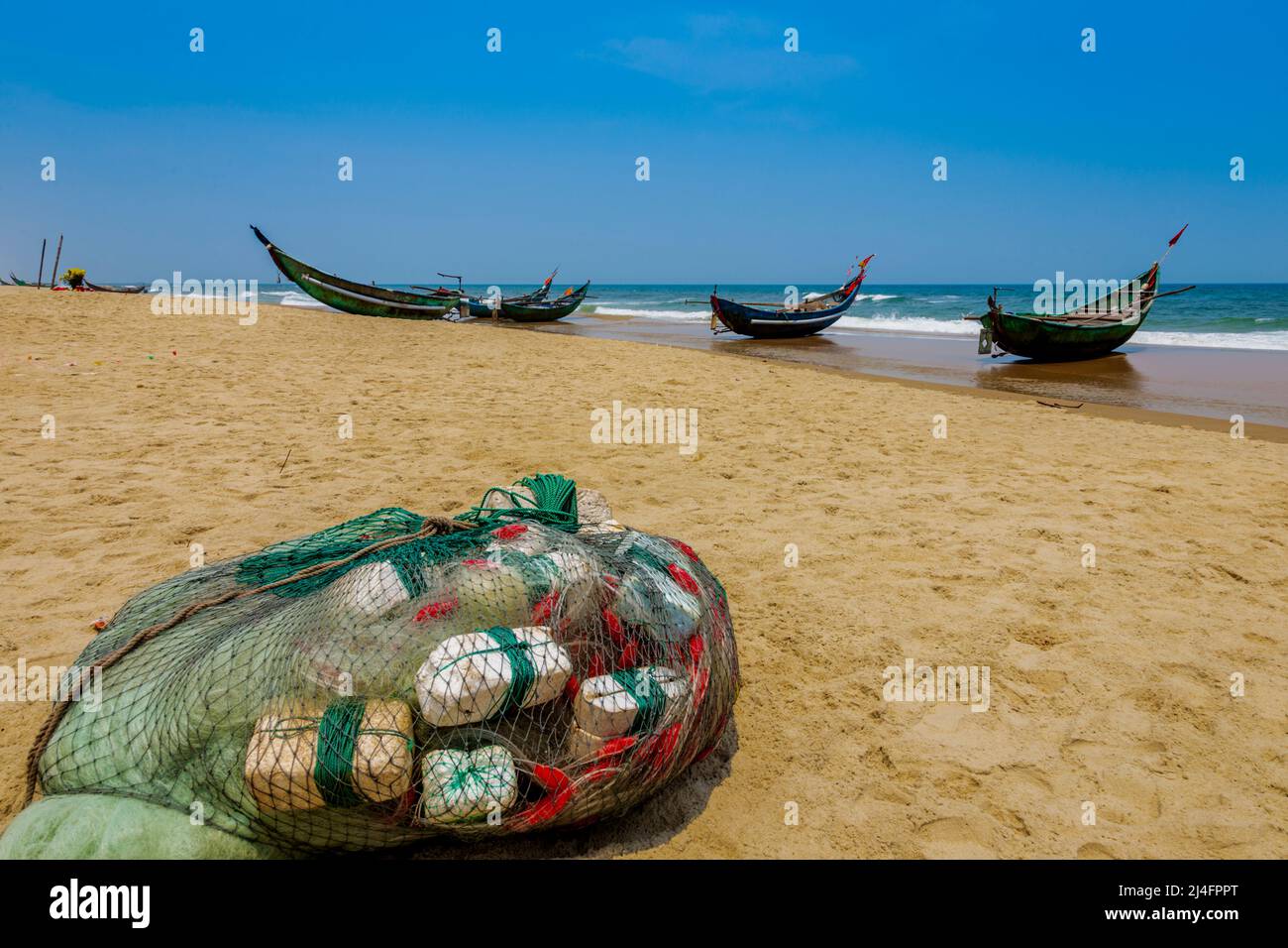 Una spiaggia di sabbia con 3 barche da pesca allineate lungo il bordo dell'acqua nel Mare del Vietnam Orientale. Foto Stock