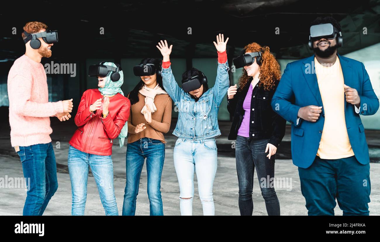 Giovani amici multirazziali che hanno esperienza di simulazione con futuristici occhiali di realtà virtuale - tecnologia e concetto metaverse Foto Stock