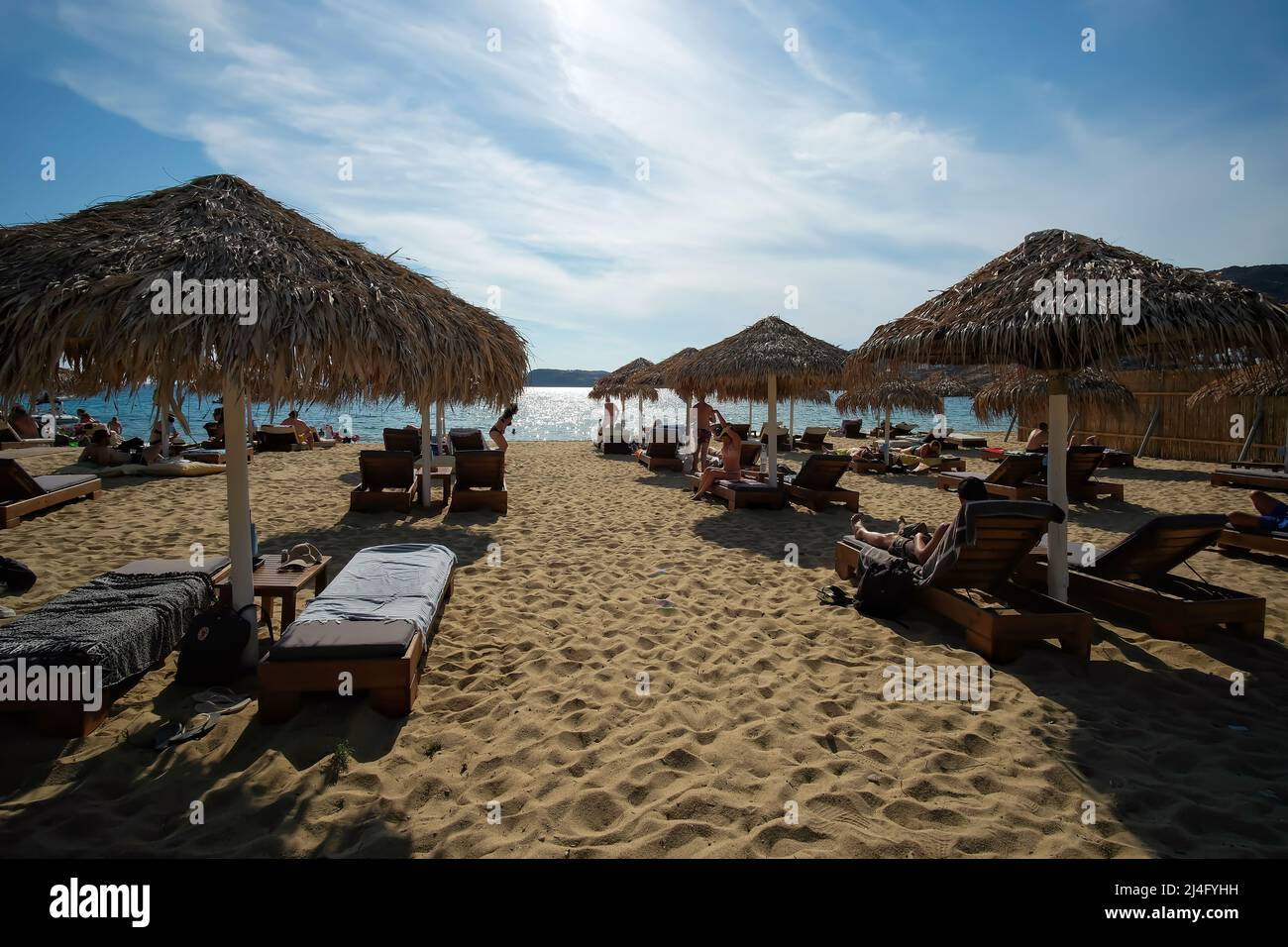 IOS, Grecia - 12 giugno 2021 : turisti che si trovano sui lettini da mare e si godono la splendida e famosa spiaggia di Mylopoatas in iOS Foto Stock