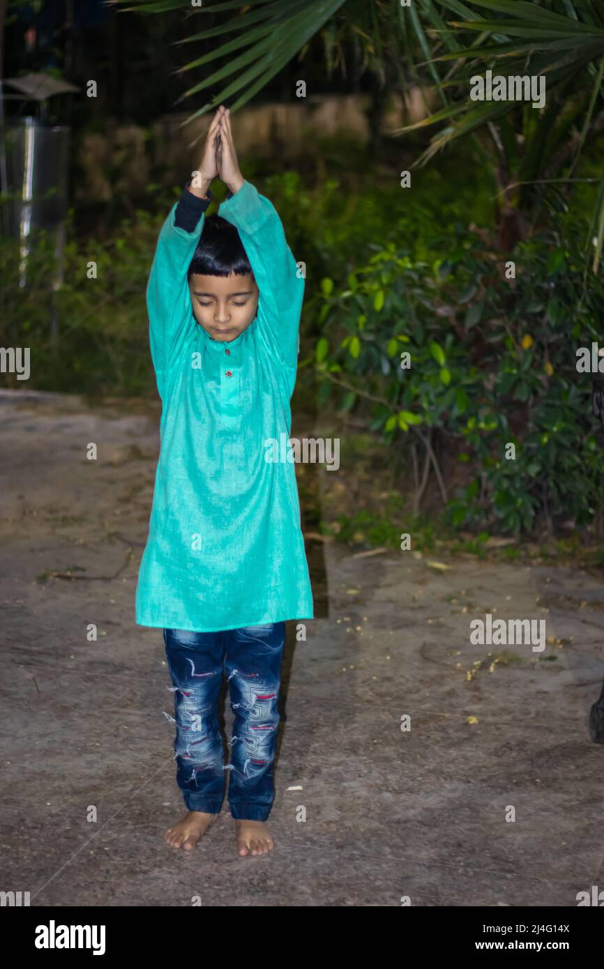 bambino giovane meditating in abito tradizionale alla sera da angolazioni diverse Foto Stock