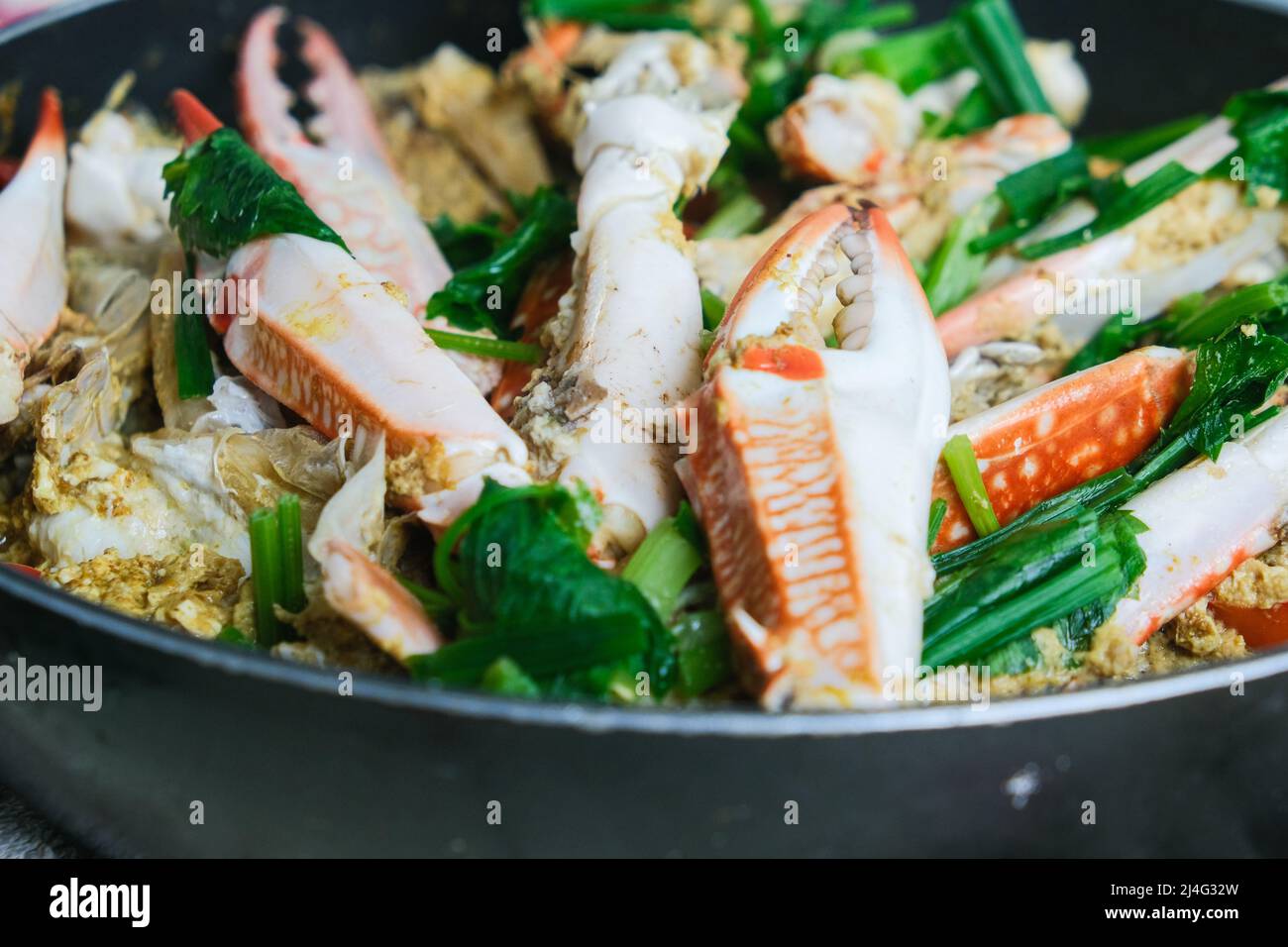 Mescolare il granchio di curry fritto in una padella Foto Stock