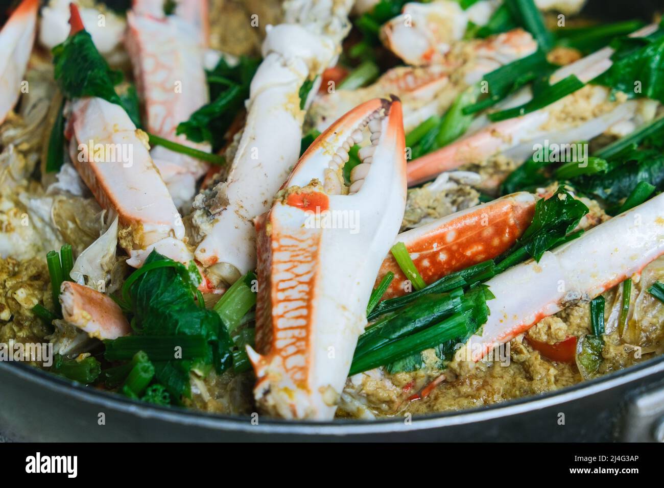 Mescolare il granchio di curry fritto in una padella Foto Stock