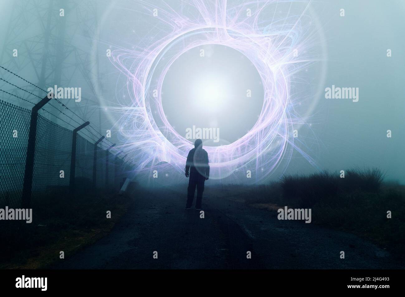 Un concetto fantasy di una figura che guarda un portale misterioso e luminoso. In una giornata di inverni di nebbia spoky Foto Stock