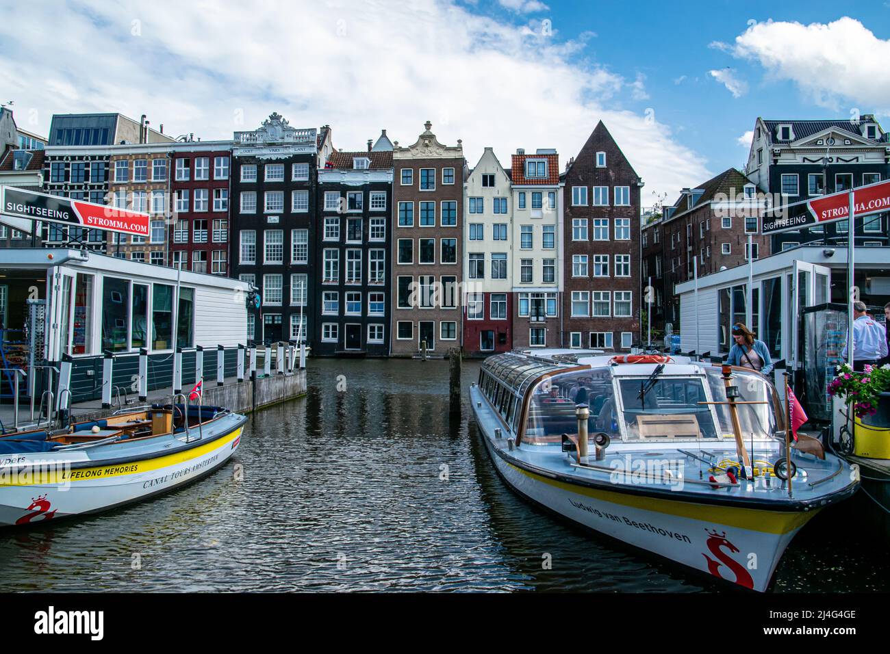 Paesaggio urbano di Amsterdam, vista di uno dei canali con barche e turisti in una giornata di sole. Foto Stock