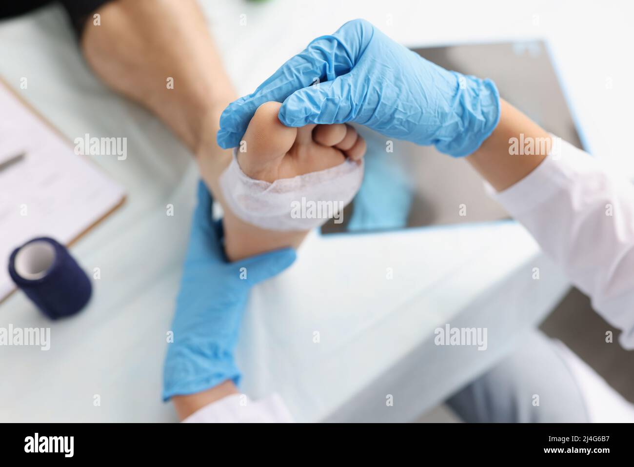 Il medico diagnostica il dolore e le calli sulle suole dei piedi Foto Stock