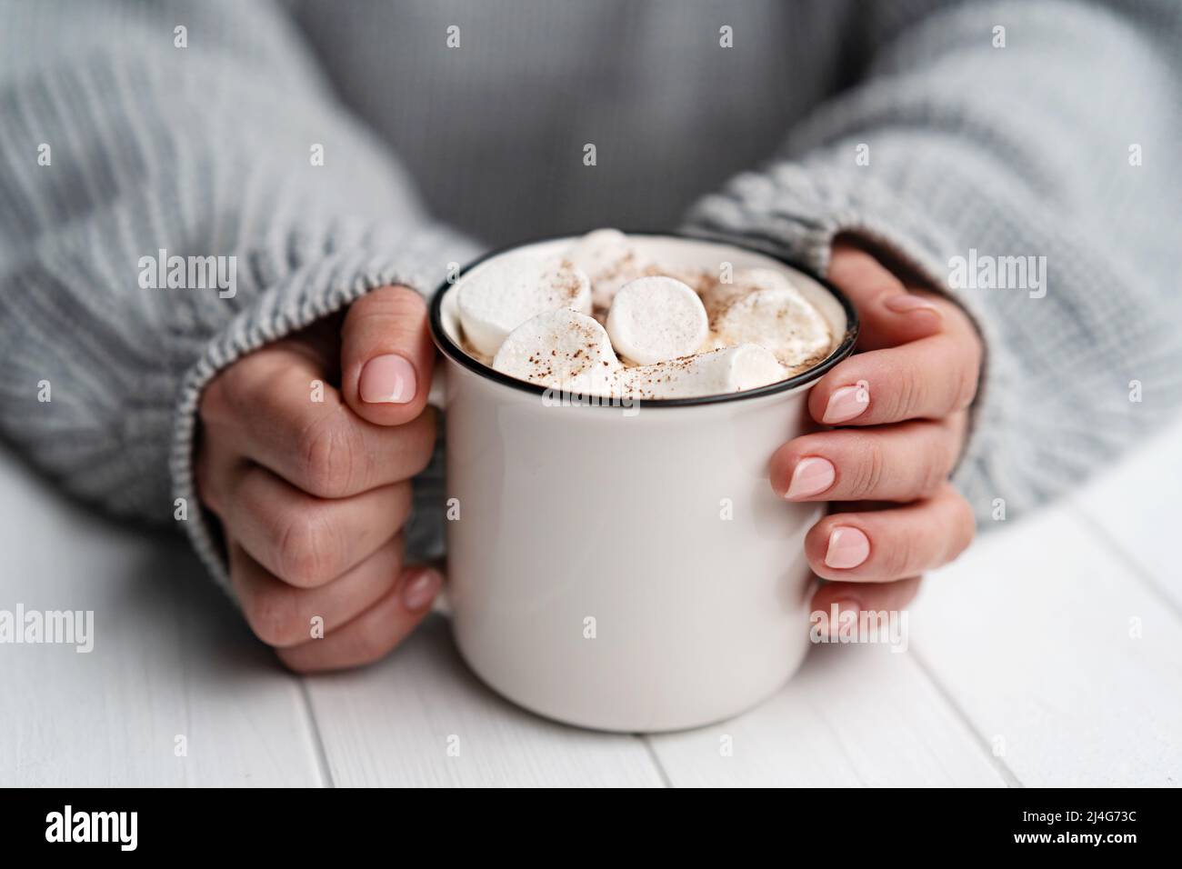 Donna che tiene una tazza con cacao e marshmallow Foto Stock