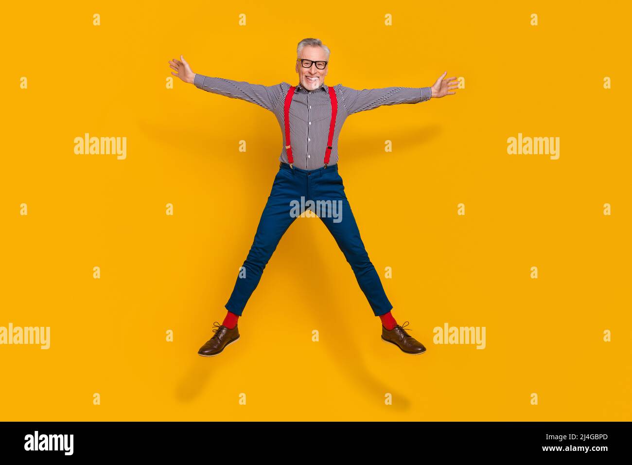 Foto a tutta lunghezza di buon umore energico nonno sensazione di giovani salti isolati su sfondo di colore giallo Foto Stock