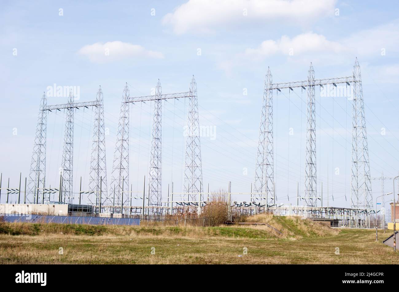 Grandi poli elettrici per il trasporto di elettricità con pannelli solari in primo piano a Nijmegen, nei Paesi Bassi Foto Stock