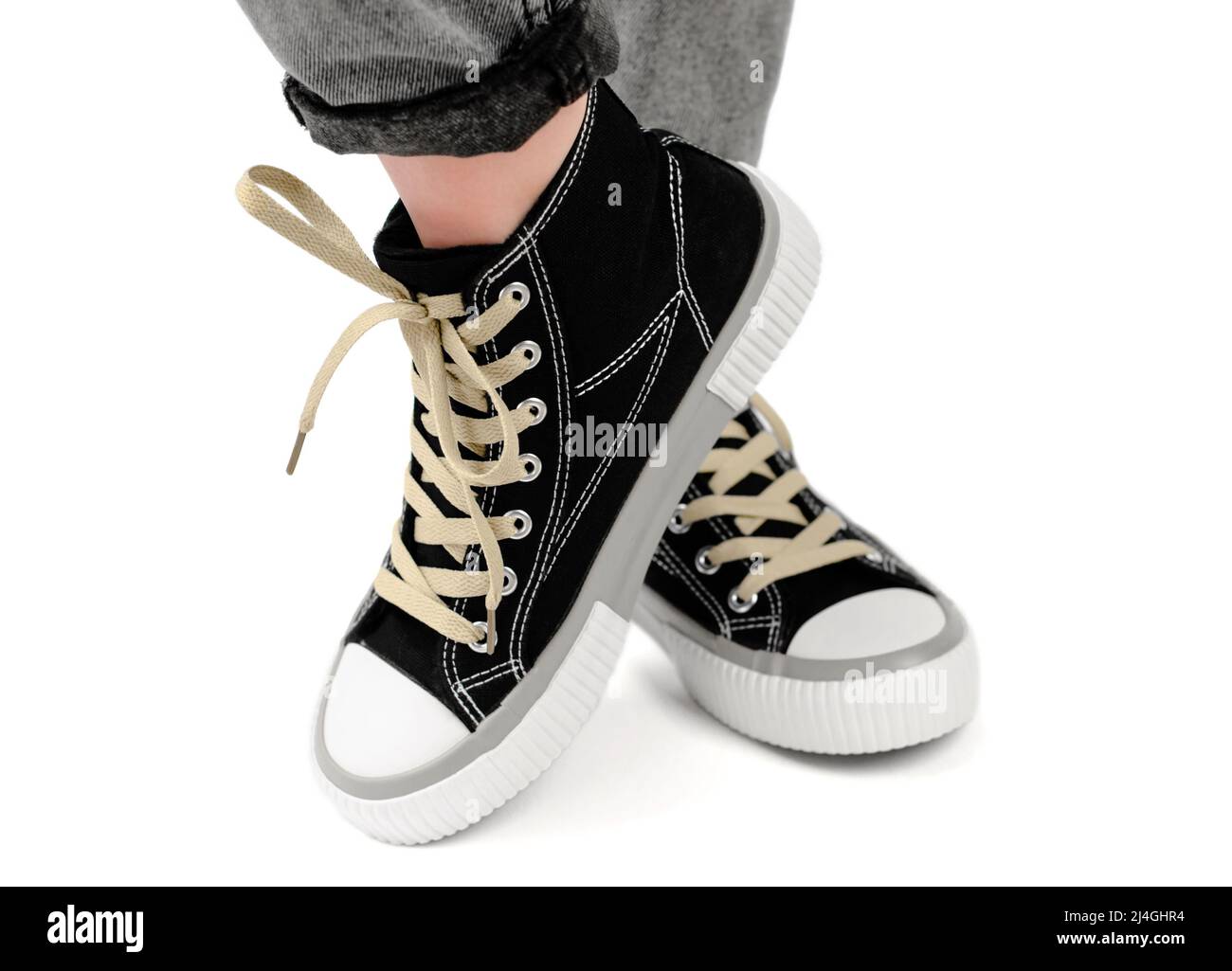 Sneaker eleganti sulle gambe femminili da vicino su sfondo bianco. La donna  indossa moderne sneakers nere Foto stock - Alamy