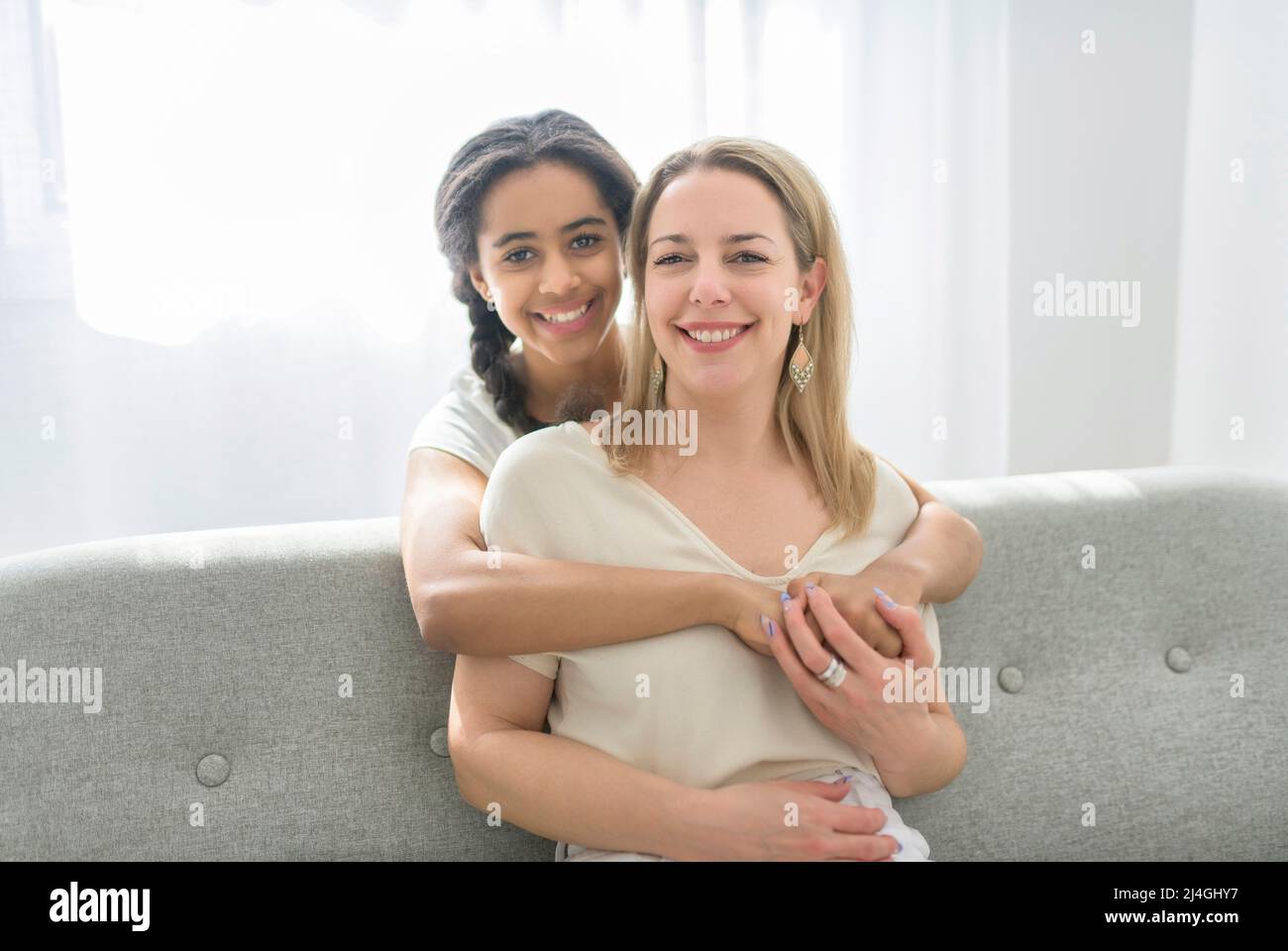 Adorabile figlia teen nera con madre si siede sul divano a casa Foto Stock