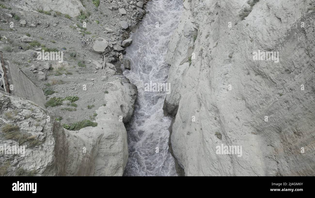 Cascata di montagna. Azione. Sottili ruscelli con gocce d'acqua corrono su rocce di montagna e cadono. Foto Stock