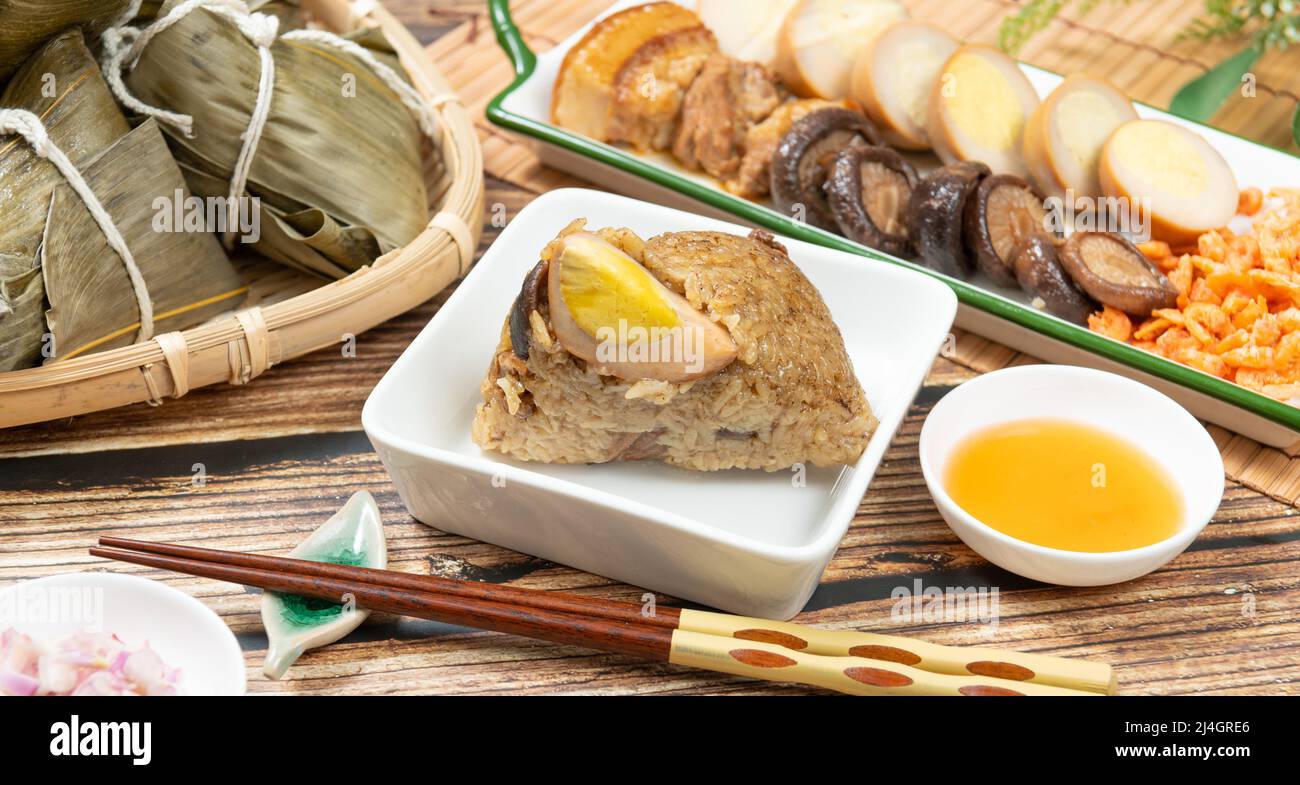Gnocchi di riso è un piatto di riso cinese tradizionale fatto di riso glutinoso e avvolto in foglie di bambù, Dragon Boat Festival sta facendo e mangiando zongzi Foto Stock