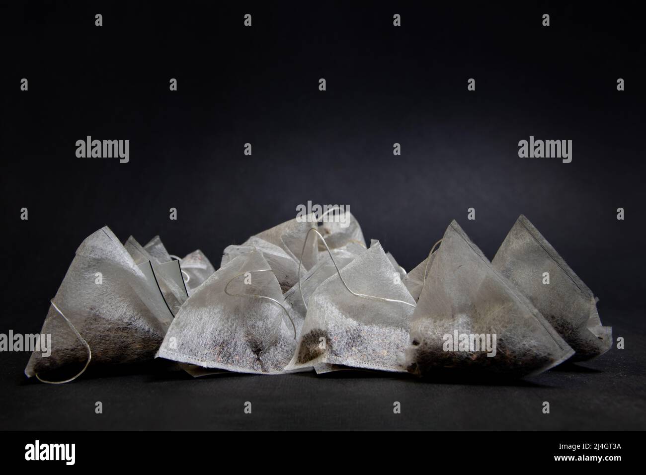 Bustine di tè triangolari su sfondo nero Foto Stock