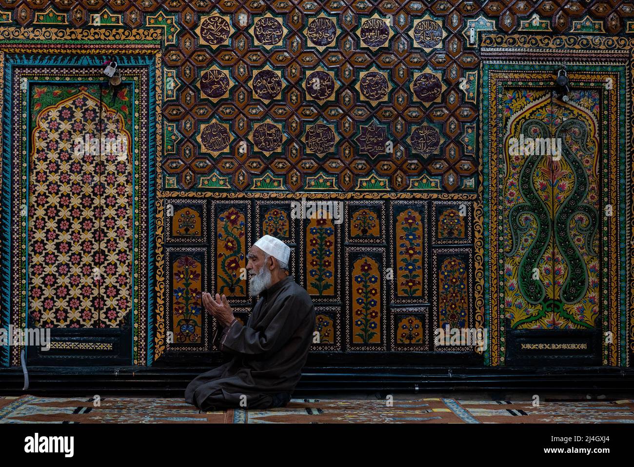 Un uomo musulmano offre le preghiere del venerdì all'interno di un Santuario durante il Ramadan. Il Ramadan, il mese più sacro dell'Islam, è un periodo di intensa preghiera, digiuno dall'alba al tramonto e feste notturne. Foto Stock