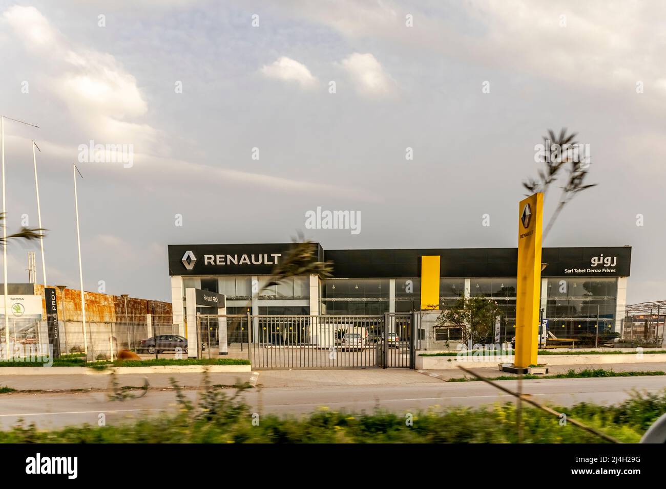 Concessionario Renault, Sarl Tabet Derraz Freres, edificio esterno giallo color Brandmark pannello con logo in caratteri arabi. Spazio bloccato e vuoto. Foto Stock