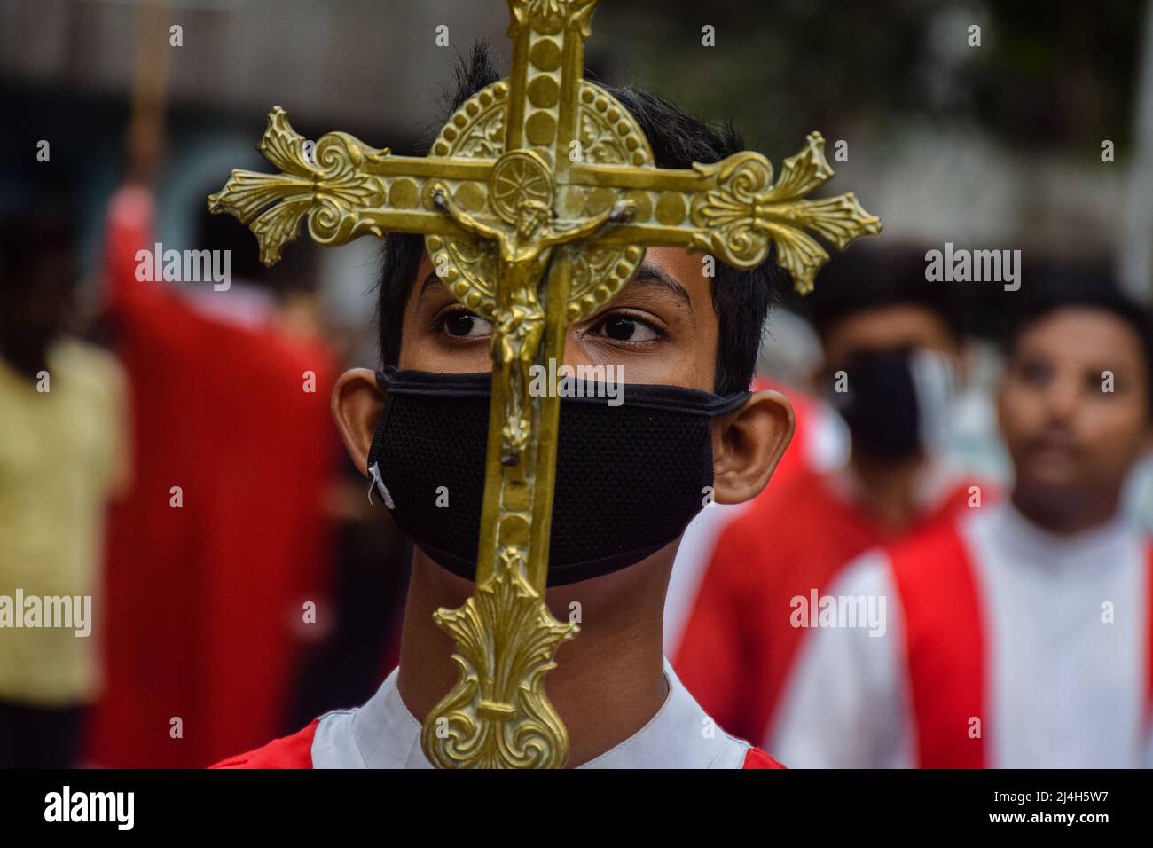 Rajpur Sonarpur, Bengala Occidentale, India. 15th Apr 2022. Un giovane devoto cattolico tiene un crocifisso durante una processione del Venerdì Santo a Kolkata. (Credit Image: © Sankhadeep Banerjee/ZUMA Press Wire) Foto Stock